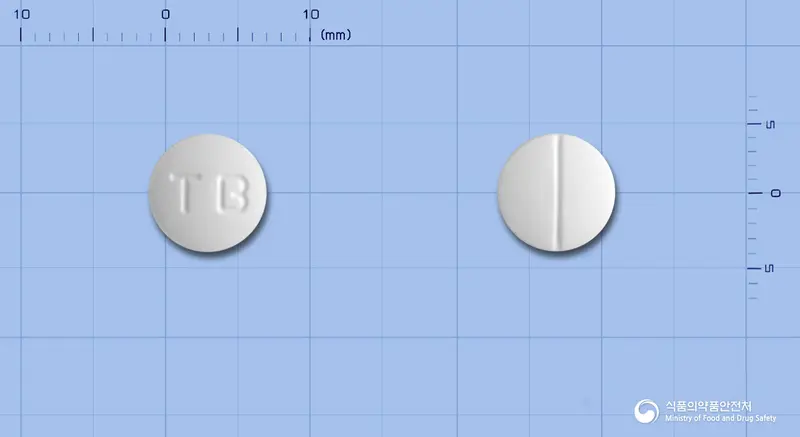 휴니즈트리메부틴말레산염정 앞뒤 사진 (흰색 원형, 각인 TB)