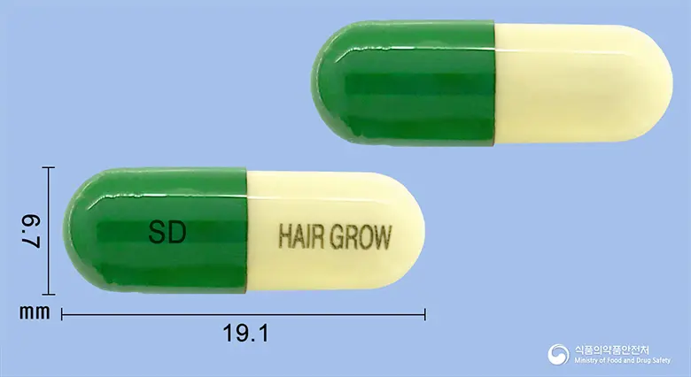 모아탄캡슐 앞뒤 사진 (초록색 캡슐, 각인 SD HAIR GROW)