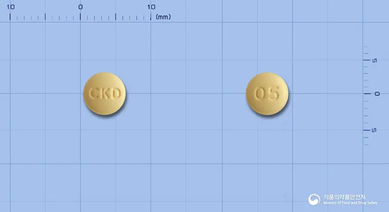 타크로벨정0.5밀리그램(타크로리무스수화물) 앞뒤 사진 (노란색 원형, 각인 CKD / 05)