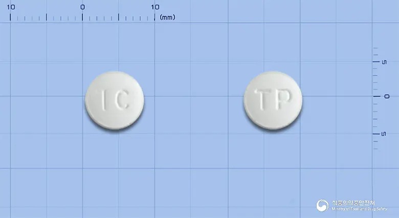 티라미정(티로프라미드염산염) 앞뒤 사진 (흰색 원형, 각인 IC / TP)