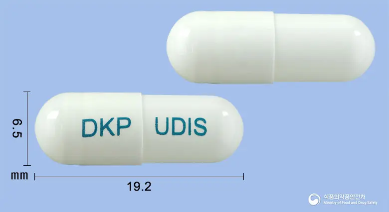 유디스캡슐 앞뒤 사진 (흰색 캡슐, 각인 DKP UDIS)