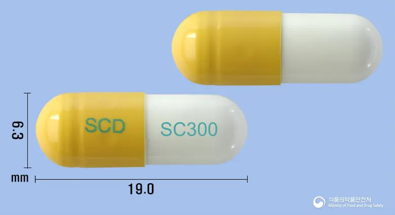 애니로민캡슐300밀리그램(테오브로민) 앞뒤 사진 (노란색 캡슐, 각인 SCD SC300)