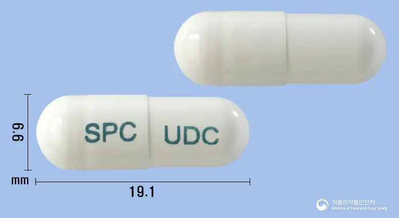 유디셀캡슐 앞뒤 사진 (흰색 캡슐, 각인 SPC UDC)