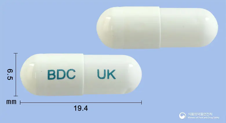유니비디캡슐 앞뒤 사진 (흰색 캡슐, 각인 BDC UK)