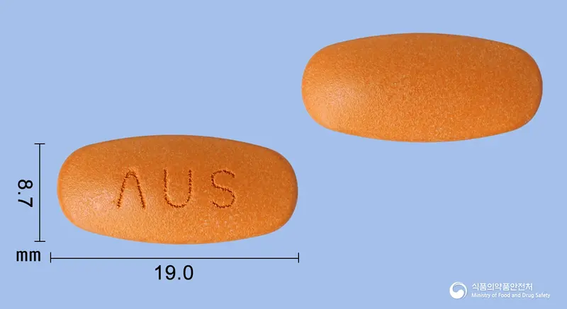 멜라큐정 앞뒤 사진 (주황색 타원형, 각인 ΛUS)