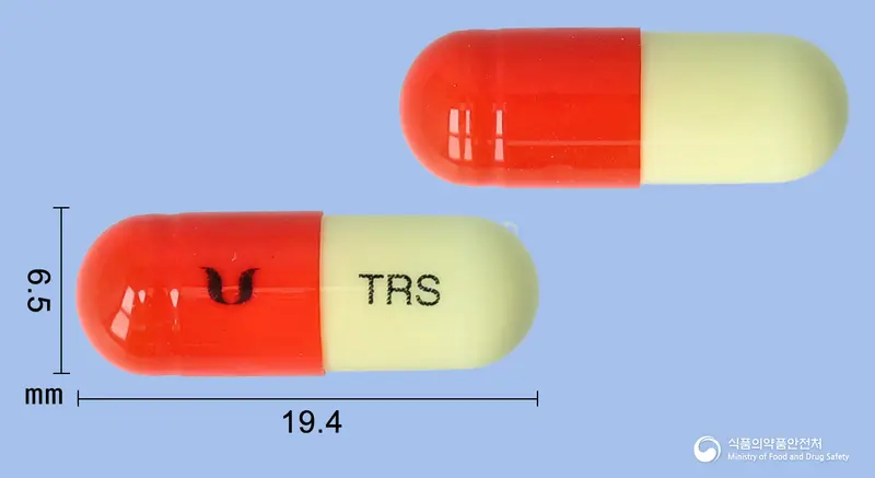 멜라녹스캡슐(트라넥삼산) 앞뒤 사진 (주황색 캡슐, 각인 TRS)