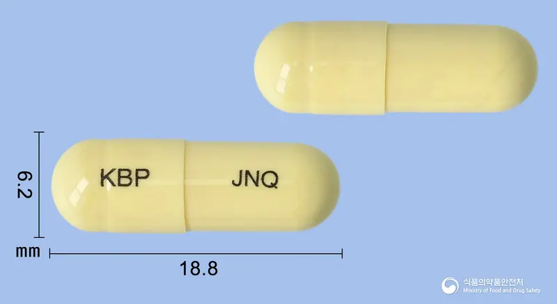 장엔큐캡슐 앞뒤 사진 (노란색 캡슐, 각인 KBP JNQ)